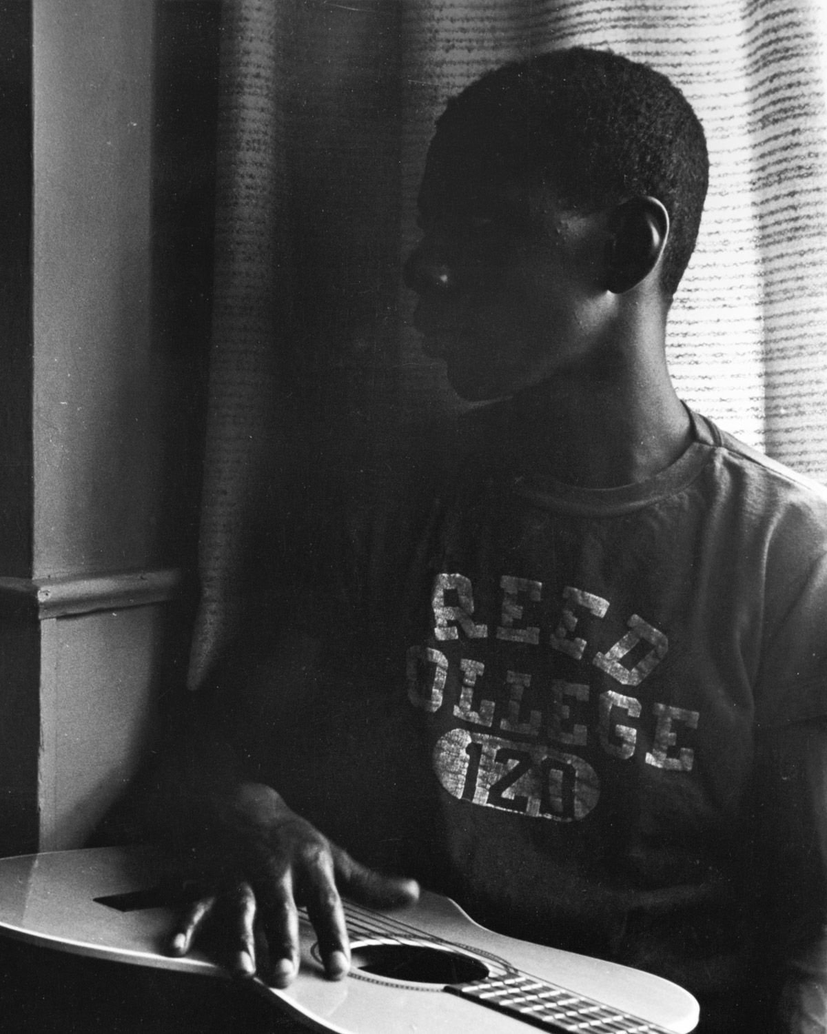 black and white photo of a black reed student holding a guitar