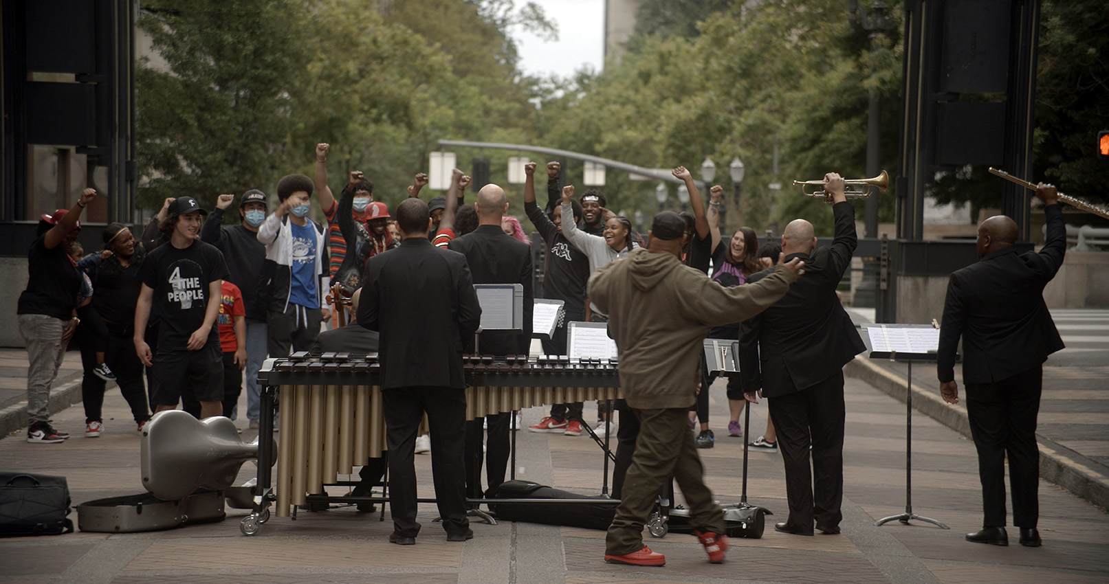 Image of musicians playing music, cheered on by fans.