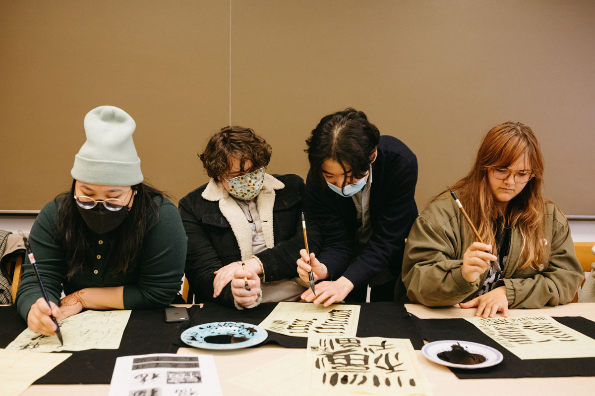 In a Paideia workshop on Chinese calligraphy, course instructor Tony Shan '23 (second from right) gives tips as Reedies create calligraphic ornaments to welcome the Year of the Rabbit.