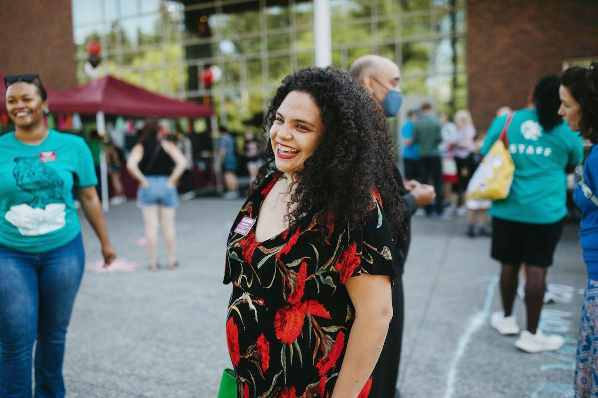 A woman smiles at an orientation event. 