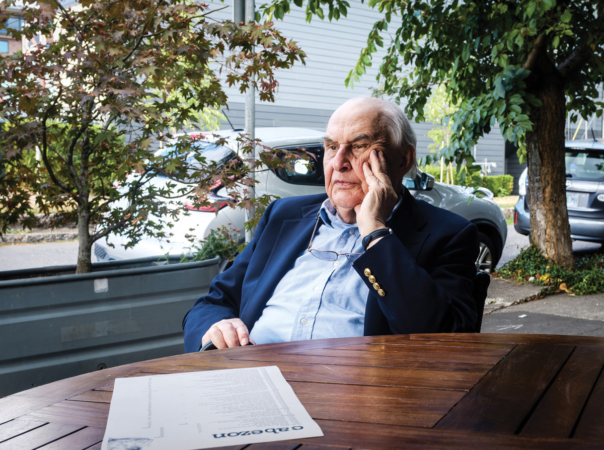 Kierstead in suit seated outside at a table