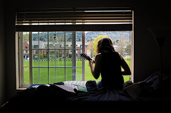 Environmental studies major Katie Halloran ’15 plays the mandolin in her Naito dorm room.