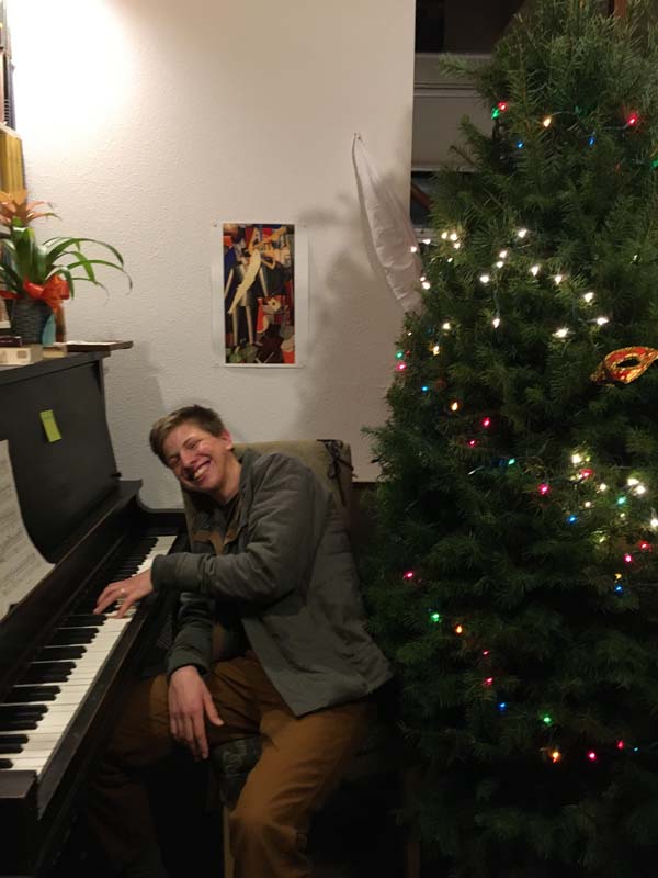 Playing piano by the Christmas tree