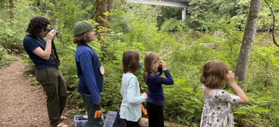 Students, using binoculars to observe something in the canyon.