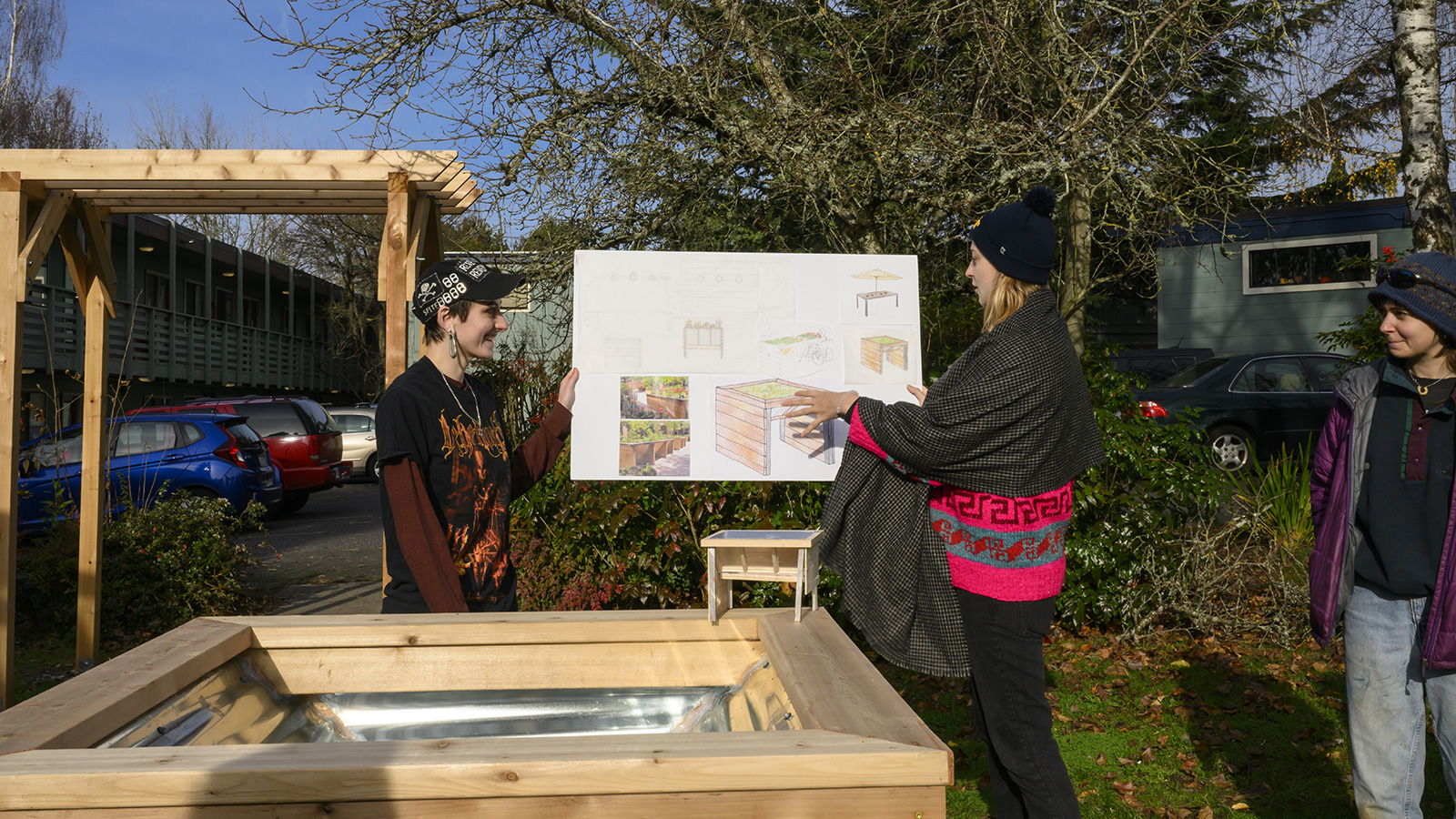 Two students presenting their plans of a wheelchair accessible raised bed