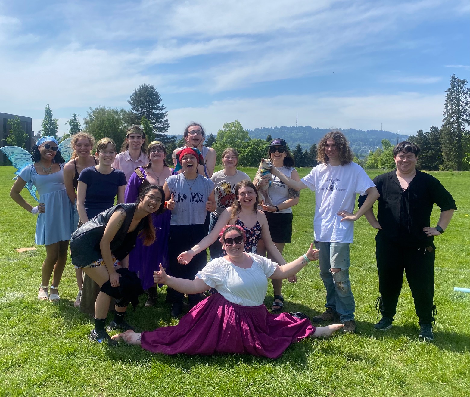 Theatre Students posing in costumes on grass field